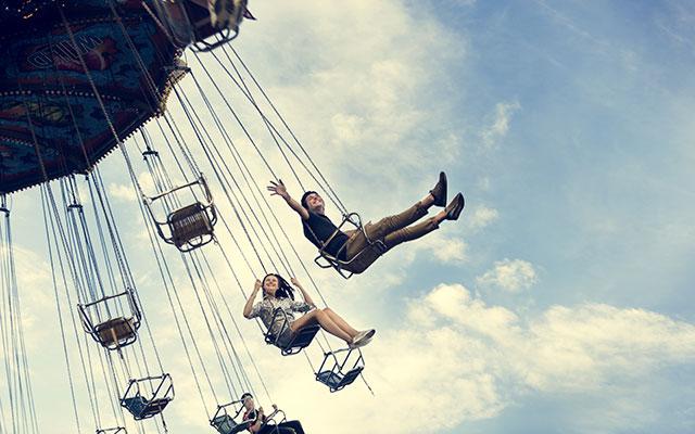 people on spinning swing amusement park ride 