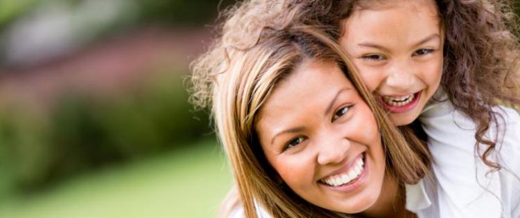 Photo of a mom giving her daughter a piggyback ride.