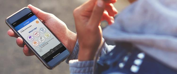 A photo of hands holding a smartphone with the Smokefree QuitSTART app on the screen.