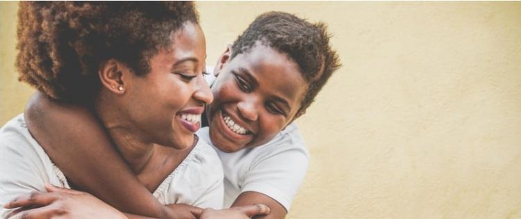 Photo of happy African American mother having fun with her child.